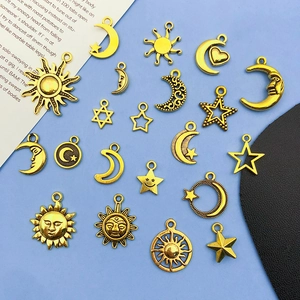 Flat lay of gold alloy sun and moon pendants for DIY jewelry making on blue background