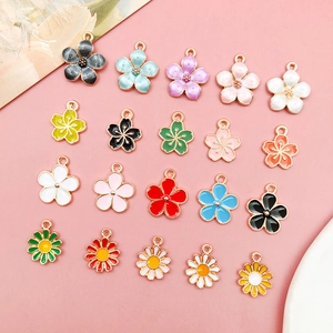 Flachbild von bunten Kirschblüten- und Gänseblümchen-Anhängern für DIY-Schmuckherstellung