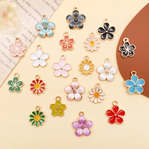 Flachbild von bunten Emaille-Blumenanhängern und Gänseblümchen für DIY-Schmuckherstellung