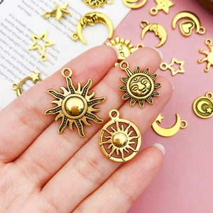 Detail of vintage gold alloy pendants with sun, moon, and star charms for DIY jewelry making
