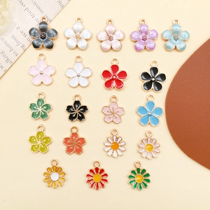 Flachbild von bunten Emaille-Kirschblüten- und Gänseblümchen-Anhängern für DIY-Schmuck