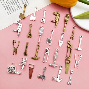 Makroansicht kleiner Legierungs-Werkzeuganhänger in Silber und Bronze für DIY-Schmuck