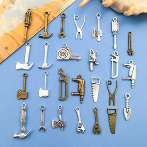 Detail von DIY-Alloy-Werkzeuganhängern mit Mini-Schlüssel, Hammer und Säge