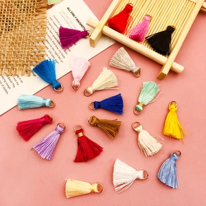 Close-up of colorful mini thread tassels with gold jump rings for DIY jewelry making