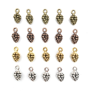 Pendentifs pommes de pin pour bijoux DIY en quatre finitions métalliques sur fond blanc
