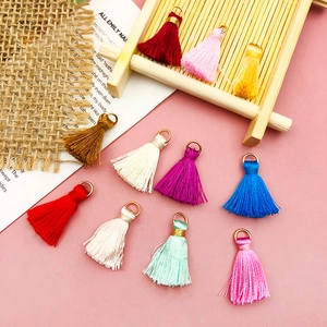 Close-up of colorful mini silk tassels with gold metal rings for DIY craft accessories