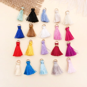 Macro view of 20 colorful mini silk tassels with golden metal rings for DIY jewelry making