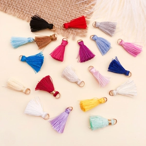 Close-up of colorful mini silk tassels with golden rings for DIY crafts and accessories
