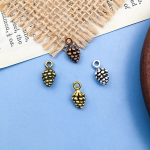 Détail de pendentifs en forme de pomme de pin en quatre finitions pour bijoux