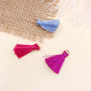 Close-up of mini silk tassels in blue, pink, and purple with golden metal rings