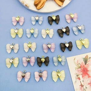 Gros plan de pendentifs nœuds en acrylique coloré avec cœurs pour création de bijoux