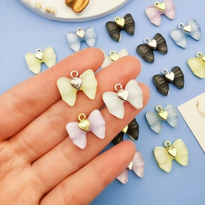 Vue détaillée de breloques nœuds en acrylique avec anneaux coeur pour bijoux DIY