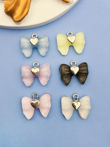 Six breloques nœuds en acrylique coloré avec cœur argenté pour la création de bijoux