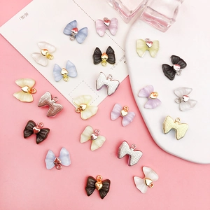 Vue macro de pendentifs nœuds en acrylique colorés avec cœurs et boucles métalliques