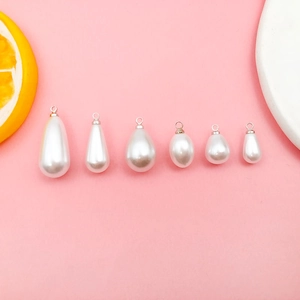 Macro shot of six different sizes white teardrop pearl pendants for DIY jewelry making