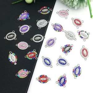 Detail van ovale Maria-bedeltjes met kleurrijk email en kristallen voor DIY-sieraden