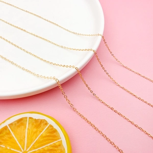 Detail of 18K gold-plated copper O-chains for DIY jewelry on a white ceramic plate