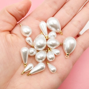 Waterdrop-shaped pearl pendants in various sizes with golden loops for DIY jewelry
