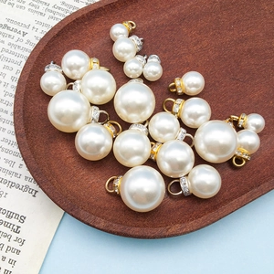 Makroaufnahme verschiedener Strass-Perlenanhänger auf Vintage-Holz für DIY-Schmuck