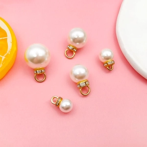 Nahaufnahme von DIY-Perlenanhängern mit Gold-Rhinestone-Akzenten auf Pink