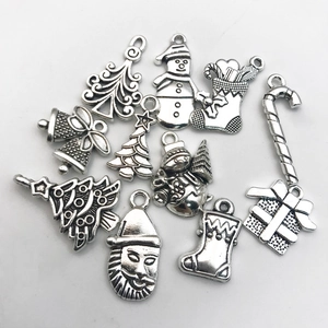 Vista detallada de colgantes navideños de plata vintage con motivos festivos y texturas en relieve