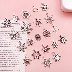 Detailed close-up of 20 assorted silver snowflake charms for DIY jewelry making