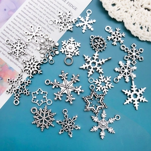 Silver snowflake alloy pendants for DIY bracelets jewelry making on vintage background