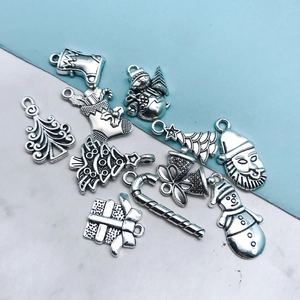 Detalle de dijes navideños de plata vintage para bisutería DIY con motivos festivos