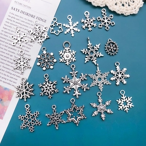 Detailed view of silver alloy snowflake charms for DIY jewelry making sets