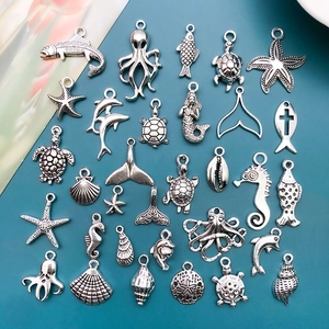 Detailed macro view of vintage silver ocean charms including starfish and sea turtles