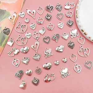 Flat lay of vintage silver heart charms in various designs for DIY jewelry making