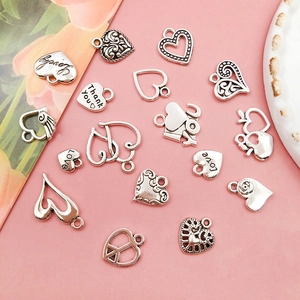 Detailed view of assorted silver alloy heart charms with engraved love motifs for DIY jewelry