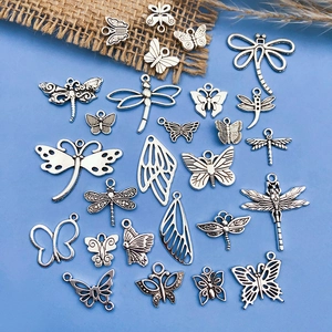Macro view of vintage silver alloy butterfly and dragonfly charms for DIY jewelry making