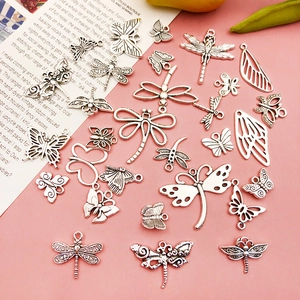 Detailed view of silver insect charms featuring butterfly and dragonfly carvings for DIY