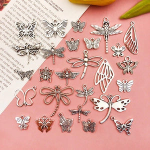 Detail of vintage silver insect pendants featuring butterfly and dragonfly hollow designs
