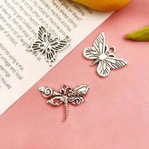Macro detail of antique silver alloy butterfly and dragonfly charms for DIY jewelry