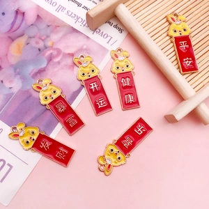 Gros plan de breloques lapin en alliage avec vœux du Nouvel An chinois en finition émail rouge