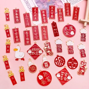 Détail de breloques en émail rouge de style chinois avec symboles porte-bonheur dorés