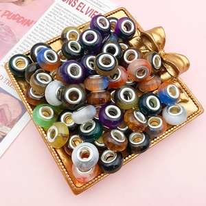 Gradient cat eye glass beads with silver metal cores in a decorative gold tray