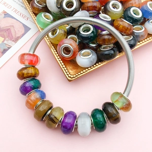 Colorful gradient cat-eye beads on silver spiral bracelet with vibrant resin charms