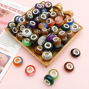 Macro shot of colorful cat eye beads with silver metal cores on a decorative tray