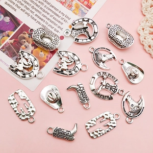 Detailed view of vintage silver western charms like cowboy boots and hats for DIY jewelry