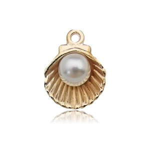 Detailed macro view of a golden shell pendant with an elegant inset white pearl