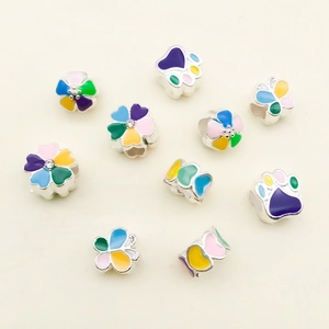 Macro view of colorful enamel charms featuring flower, cat paw and butterfly designs