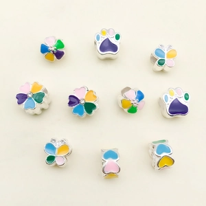 Macro shot of colorful enamel charms with floral and animal prints for DIY bracelets