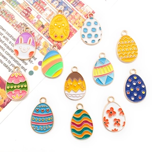 Detailed macro view of 12 assorted Easter egg enamel charms with rabbits and chickens