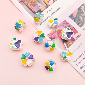 Macro view of colorful enamel flower and heart charms with zircon for DIY jewelry