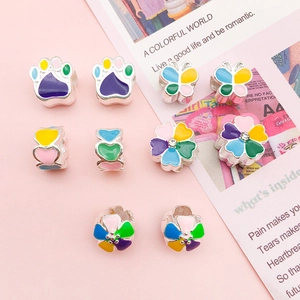 Detailed view of colorful enamel flower and paw charms for DIY bracelets and necklaces