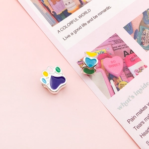 Detailed shot of colorful enamel cat paw and triple heart charms for DIY bracelets