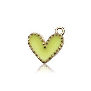 Dettaglio macro di un ciondolo a cuore smaltato verde chiaro con bordi dorati per gioielli